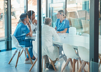 Buy stock photo Doctors, healthcare team and meeting for a discussion, planning or training at table. Diversity men and women medical group talking about communication strategy, virus or surgery in a hospital