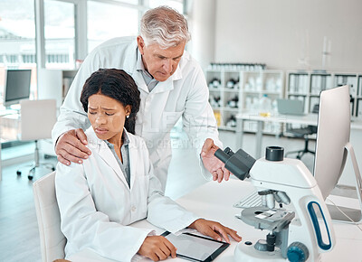 Buy stock photo Shot of a young scientist looking uncomfortable while being touched on her shoulder by a senior scientist in a lab
