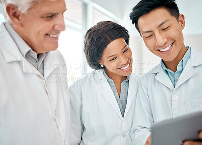 Buy stock photo Shot of a group of scientists working together on a digital tablet in a lab