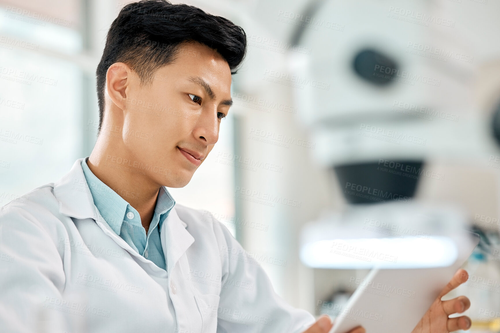 Buy stock photo Shot of a young scientist using a digital tablet in a lab