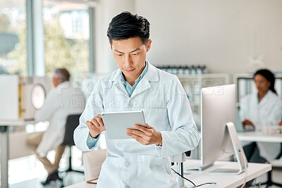 Buy stock photo Shot of a young scientist using a digital tablet in a lab