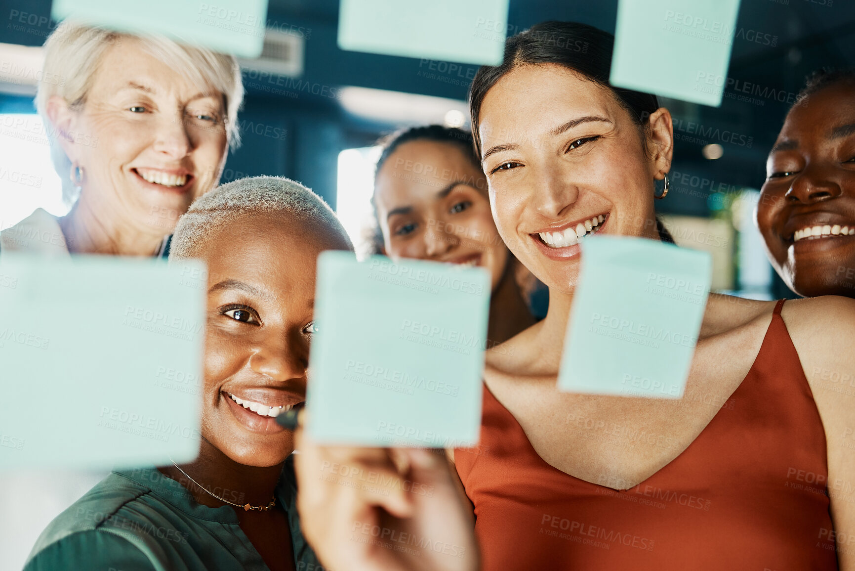 Buy stock photo Cropped shot of an attractive and diverse group of businesswomen working with sticky notes on a glass wipe board in the boardroom