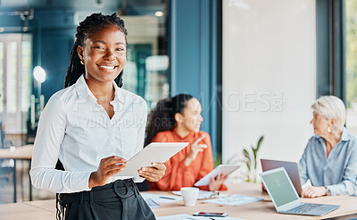 Buy stock photo Cropped portrait of an attractive young businesswoman using her tablet while standing in the boardroom