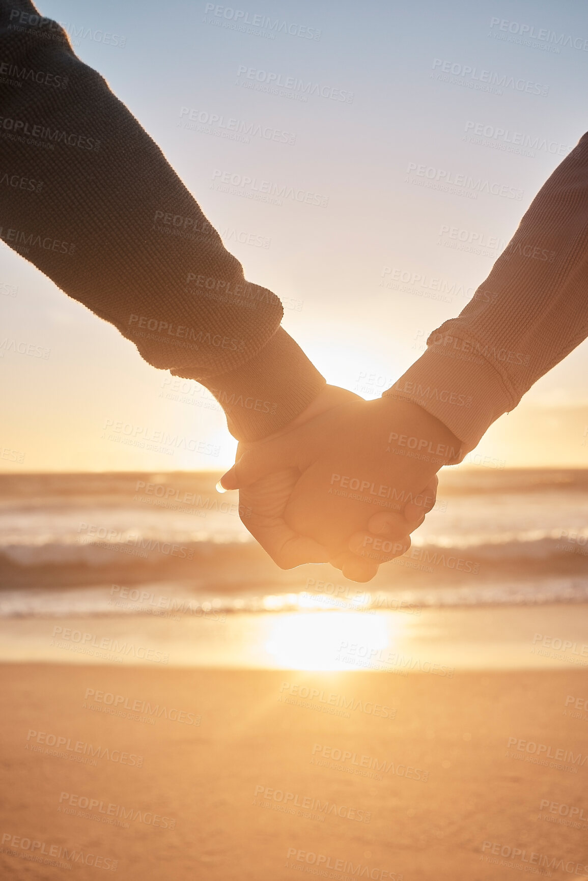 Buy stock photo Couple, sunset and holding hands at beach for date, relationship and romantic moment together. People, relax and love gesture by ocean with partner, closeup and view for travel, holiday and loyalty