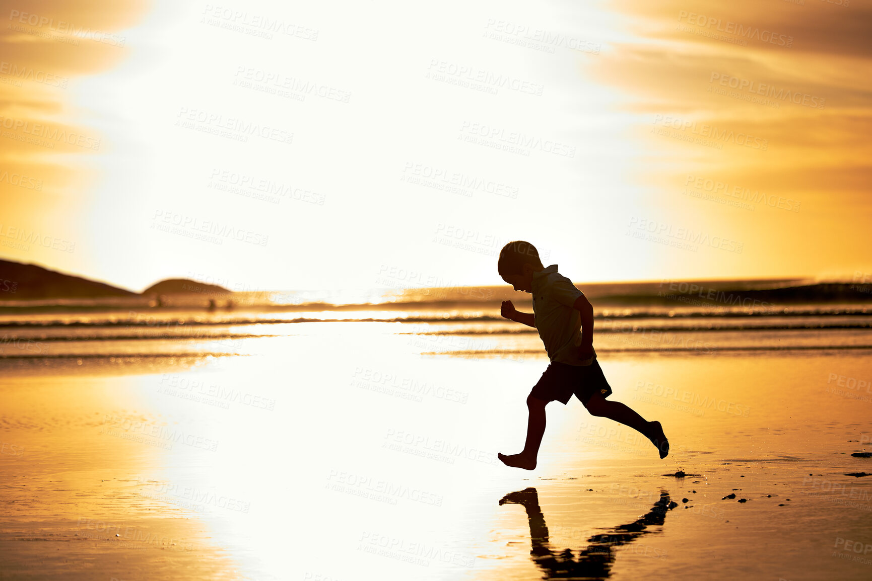 Buy stock photo Beach, child and boy running at sunset for playing games and enjoying exercise on ocean trip. Silhouette, energy and kid on sand alone sea chasing shadow in nature for holiday vacation or weekend