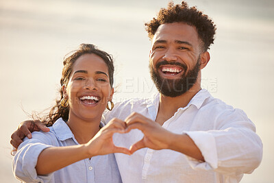Buy stock photo Shot of a couple holding a heart with their hands while bonding at the beach