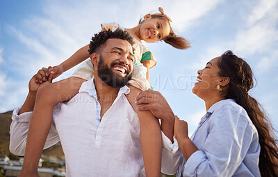 Buy stock photo Shot of a young couple bonding with their daughter at the beach