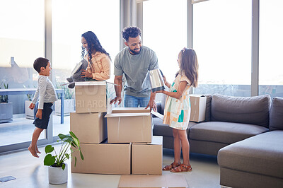 Buy stock photo Shot of a young family unpacking in the new house