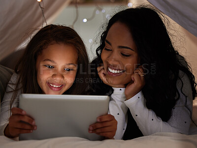 Buy stock photo Shot of a young mother and daughter using a digital tablet together at home
