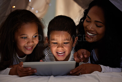 Buy stock photo Shot of a young mother and her children using a digital tablet together at home