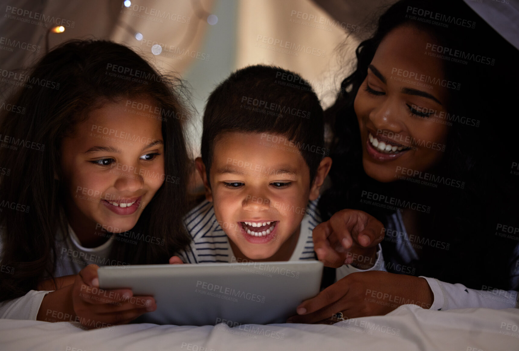Buy stock photo Shot of a young mother and her children using a digital tablet together at home