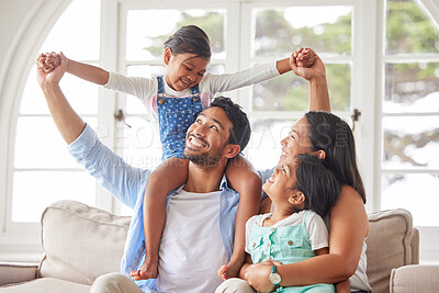 Buy stock photo Young ethnic couple relaxing with their two daughters and enjoying family time at home