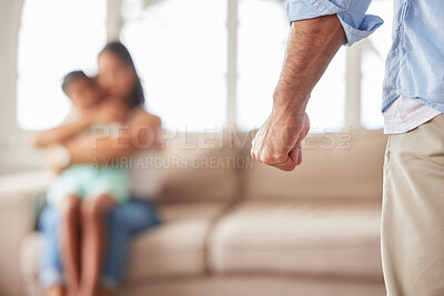Closeup shot of an angry, abusive mans fist before harming his daughter and wife on the sofa at home