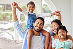 Young ethnic couple relaxing with their two daughters and enjoying family time at home