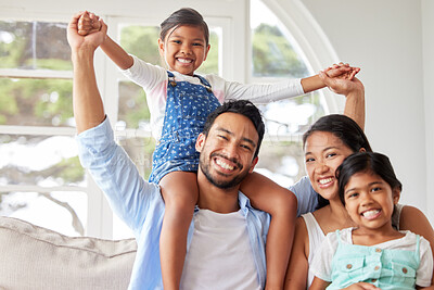 Buy stock photo Young ethnic couple relaxing with their two daughters and enjoying family time at home