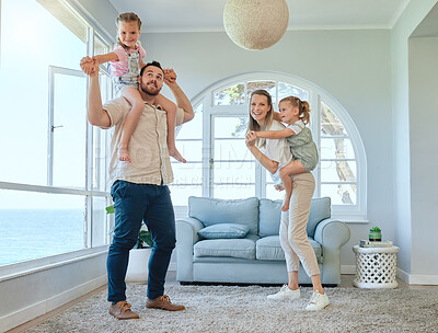 Buy stock photo Shot of a young family having fun together in the lounge at home
