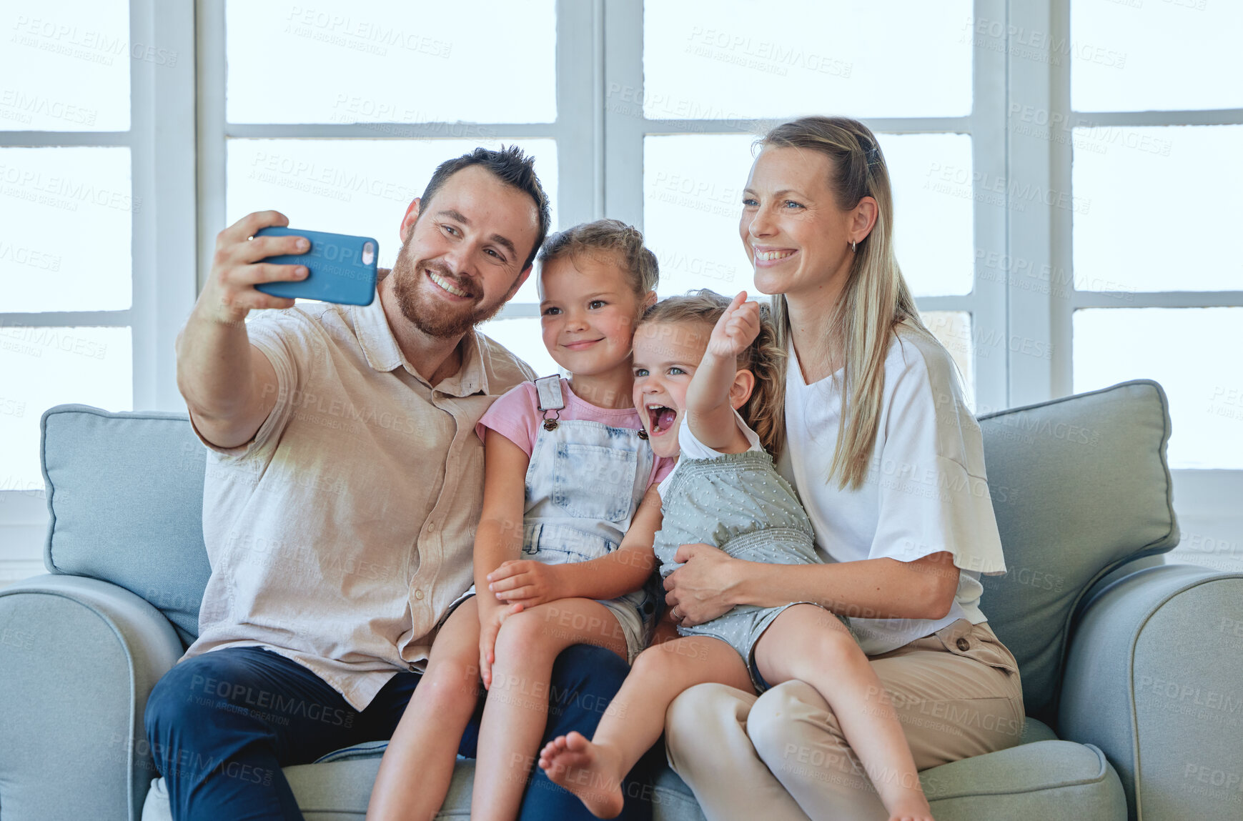 Buy stock photo Shot of a young family taking a selfie together at home