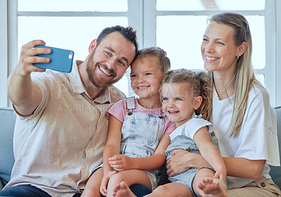 Buy stock photo Shot of a young family taking a selfie together at home