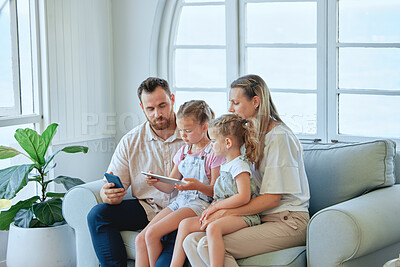 Buy stock photo Shot of a young family using a phone and digital tablet  together at home