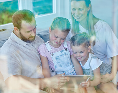 Buy stock photo Shot of a young family using a digital tablet together at home