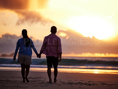 Buy stock photo Shot of a couple spending time together at the beach during sunset
