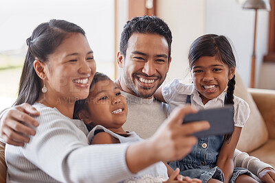 Buy stock photo Cropped shot of an affectionate young family of four taking selfies on the sofa at home