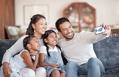 Buy stock photo Cropped shot of an affectionate young family of four taking selfies on the sofa at home