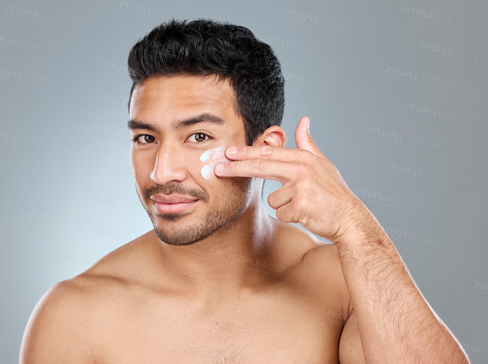 Buy stock photo Man, happy and portrait with face cream in studio for skincare, hydration and skin tone with dermatology or cosmetology. Person, lotion and product on gray background for facial care, shine and glow.