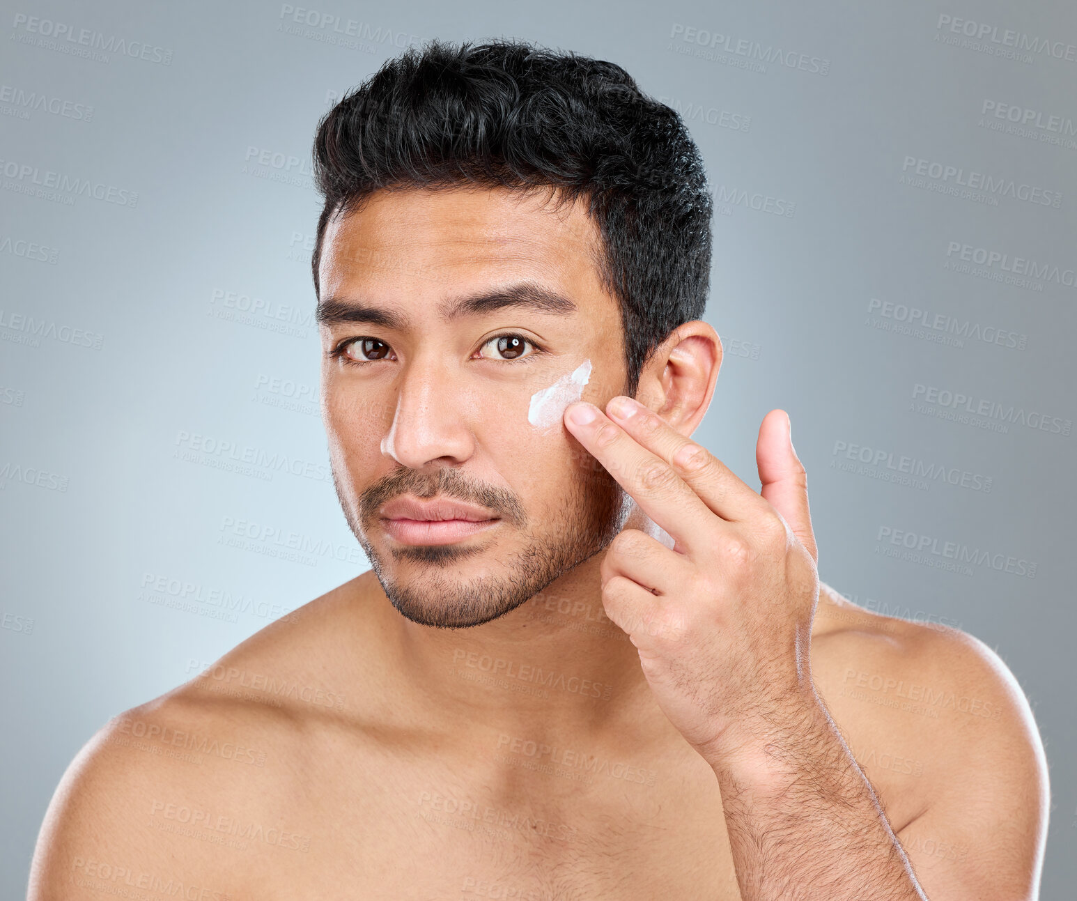 Buy stock photo Man, portrait and cream in studio for skincare, hydration and skin tone with dermatology or cosmetology. Male person, lotion and sunscreen on gray background for facial care, grooming and protection.