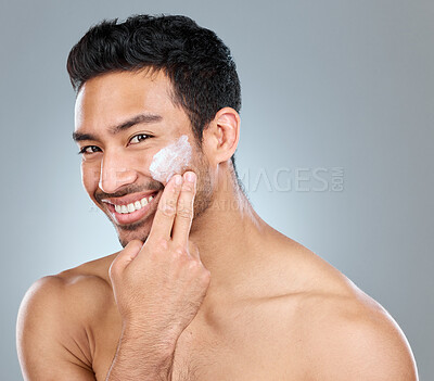 Buy stock photo Man, happy and portrait with cream on studio backdrop for skincare, hydration and skin tone with dermatology. Male person, lotion and sunscreen on gray background for facial care, grooming and glow.