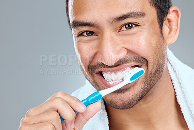 Buy stock photo Brushing teeth, grooming and portrait of Asian man in studio on gray background for wellness. Toothbrush, toothpaste and smile with face of happy person in bathroom for dental hygiene or oral care