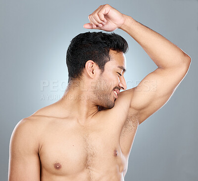 Buy stock photo Health, fresh and man smelling armpit in studio for hygiene, clean and wellness routine. Wellness, fragrance and male person checking underarm scent for deodorant or perfume by gray background.