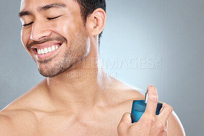 Buy stock photo Cologne, smile and man spraying neck against a gray studio background. Wellness, care and health of topless model with cosmetic product for grooming, clean skin and smell routine for body hygiene