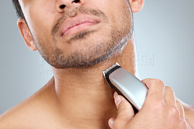 Buy stock photo Shave, electric razor and man cutting beard hair for grooming and hygiene or health on a gray studio background. Morning, routine and equipment with model with trimmer for haircare and wellness