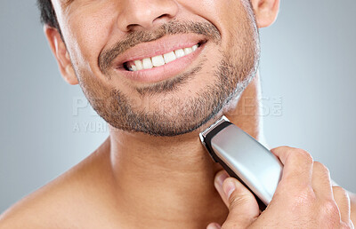 Buy stock photo Electric, razor and hand of man in studio by beard for grooming, facial epilation and wellness or skincare. Person, cosmetic tool and shaving for hair removal, gray background and closeup routine.