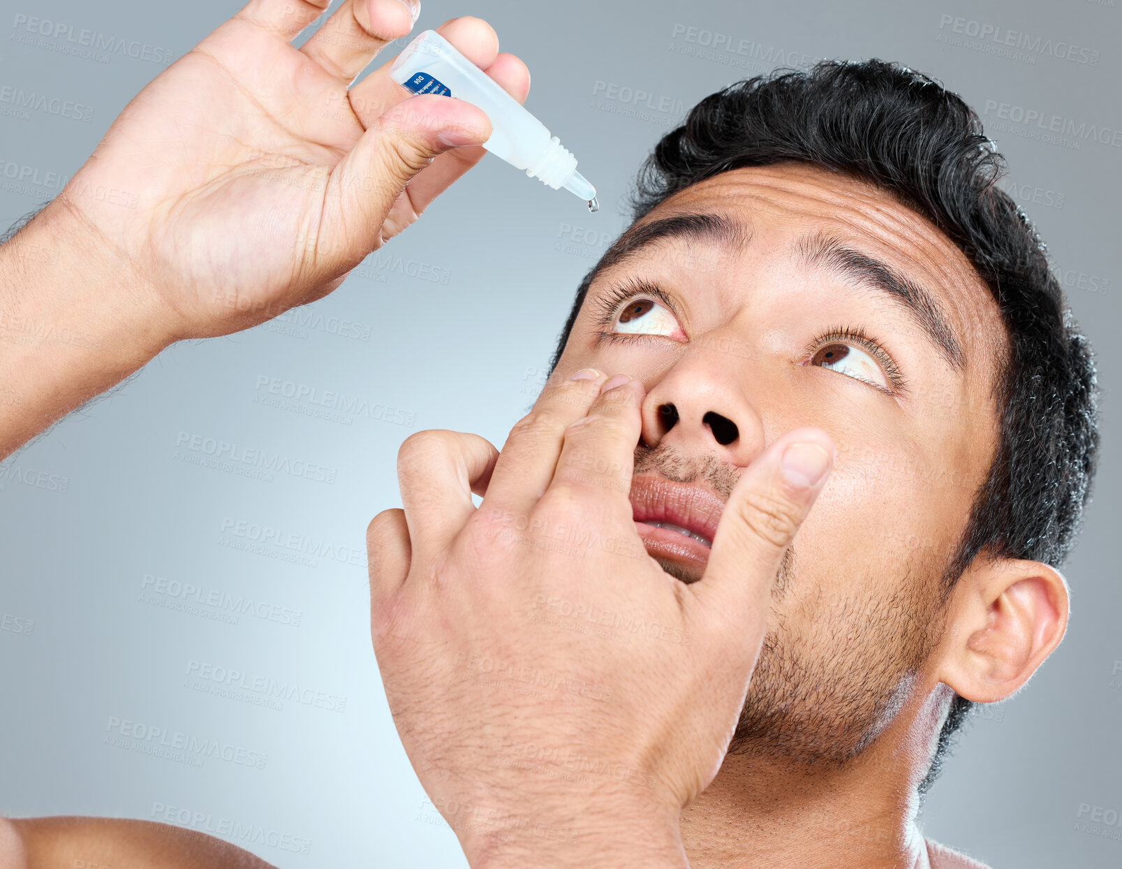 Buy stock photo Man, eye drops and vision in studio for healthcare, eyesight and medical product for allergies. Shirtless model, liquid solution and eyes to stop allergy, self care and wellness on gray background