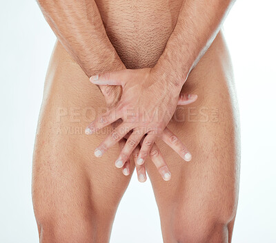 Buy stock photo Shot of a man covering his genitals against a studio background