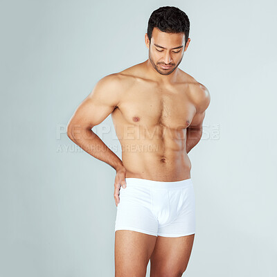 Buy stock photo Shot of a muscular young man posing against a studio background