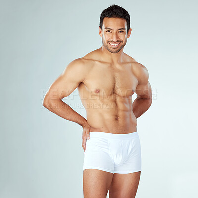 Buy stock photo Shot of a muscular young man posing against a studio background