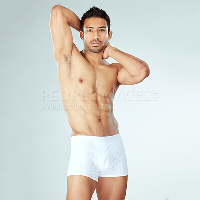 Buy stock photo Shot of a muscular young man posing against a studio background