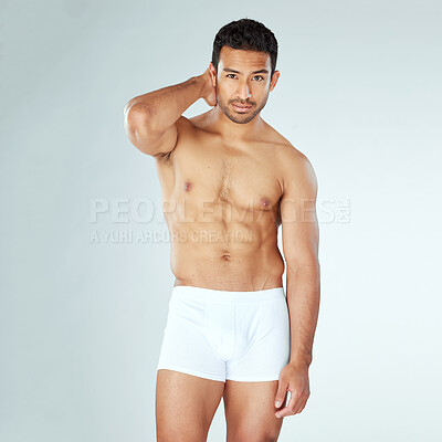 Buy stock photo Shot of a muscular young man posing against a studio background