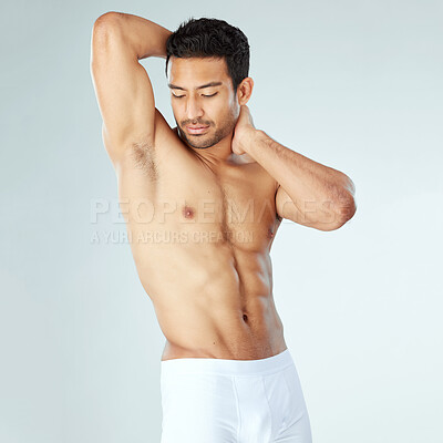 Buy stock photo Shot of a muscular young man posing against a studio background