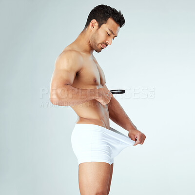 Buy stock photo Body, search and asian man with magnifying glass for genitals check, size or problem in studio on grey background. Magnifier, inspection or Japanese male model profile curious with anatomy analysis