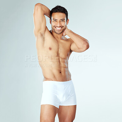 Buy stock photo Shot of a handsome muscular man posing against a studio background