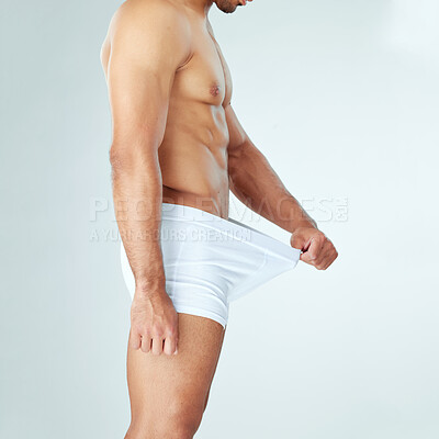 Buy stock photo Shot of a man looking into his underwear against a studio background