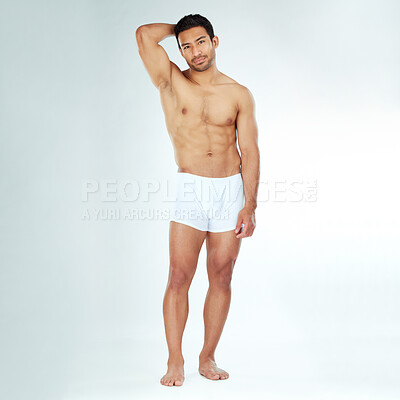 Buy stock photo Shot of a handsome muscular man posing against a studio background