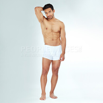 Buy stock photo Shot of a handsome muscular man posing against a studio background