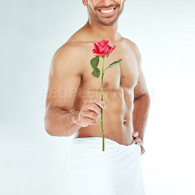 Buy stock photo Shot of an young man holding a rose against a studio background