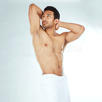 Buy stock photo Shot of a handsome young man posing against a studio background