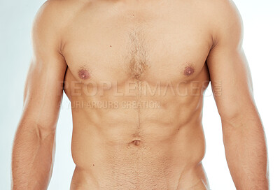 Buy stock photo Shot of a man showing off his abs against a studio background